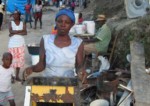Haitian woman with makeshift grill collected from the rubble. Flavia Cherry photo.